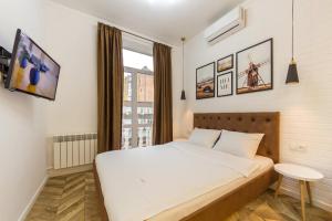um quarto com uma grande cama branca e uma janela em Idea Design Apart-Hotel Chykalenka em Kiev