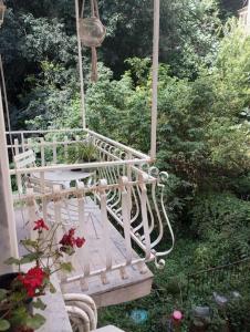 a porch swing with flowers and a hanging basket at Santa Lucia Home in Naples
