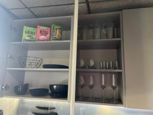 a cabinet filled with wine glasses and bowls at BRIVIBAS RESIDENCE - STONES, free PRIVAT parking, free WIFI, self check-in in Rīga