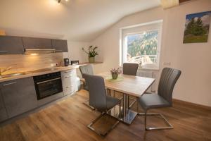 eine Küche mit einem Holztisch und Stühlen im Zimmer in der Unterkunft Ferienhaus Alois Navis in Navis