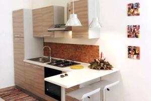 a kitchen with a sink and a stove top oven at Santa Lucia Home in Naples