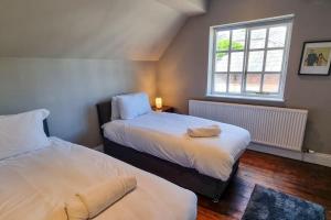 1 Schlafzimmer mit 2 Betten und einem Fenster in der Unterkunft Spacious stone cottage w/ extensive private garden in Bolton