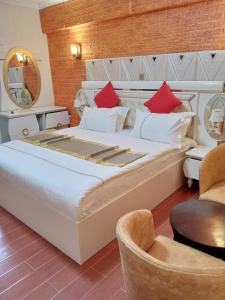 a bedroom with a large bed with red pillows at Gold Suite Hotel in Nakuru