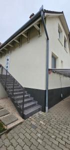 a white building with stairs and a stair railing at Boldogfalvi apartman in Debrecen
