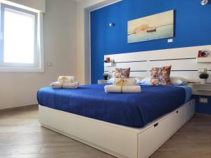 ARTrinacria Apartments - Qubba في باليرمو: غرفة نوم بسرير كبير بجدار ازرق