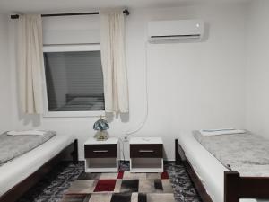 Habitación con 2 camas, ventana y espejo. en Loznica, Venera sobe en Ploča