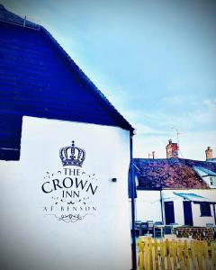 a sign on the side of a white building at The Crown Inn at Benson in Wallingford