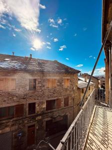 an old brick building with a white railing on a balcony at Luminoso y Céntrico Estudio, Llívia, Cerdanya in Llivia