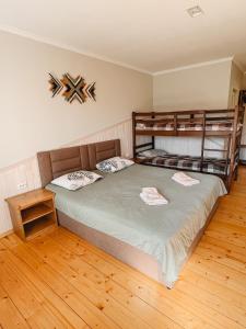 a bedroom with two bunk beds and a wooden floor at Садиба Казка in Vizhenka
