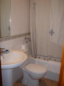 y baño con lavabo, aseo y ducha. en Hostal Pineda, en Cervera de Pisuerga
