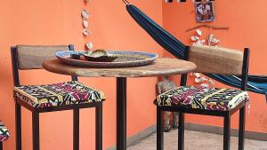 einen Tisch mit 2 Stühlen und einen Tisch mit einer Schüssel darauf in der Unterkunft AKINE TI KASSO piscine in Diembéreng