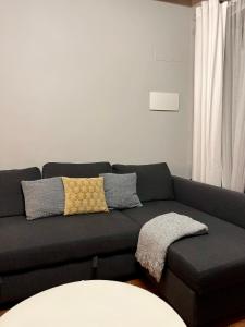 un sofá negro con almohadas en la sala de estar en Casa Rural La Chiquitita, en Alaejos