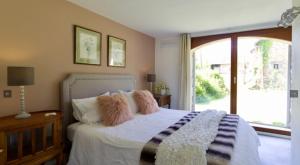 una camera da letto con un letto con cuscini e una finestra di Dordogne et Corrèze vacances - Gites a Troche