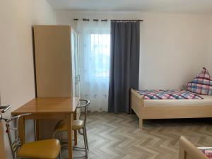 Cette petite chambre comprend un lit, une table et un bureau. dans l'établissement Apartment Natali, à Schnaittenbach