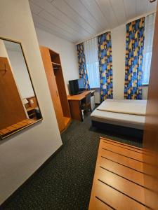 a hotel room with a bed and a desk at Hotel City Faber in Worms