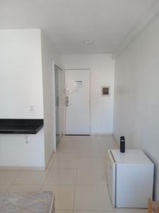 Cette chambre blanche dispose d'une porte et de carrelage blanc. dans l'établissement PRIME HOSPEDAGENS - Residencial Bellágio, à São Luís