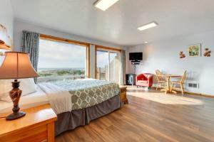 a bedroom with a bed and a large window at Sanderling Sea Cottages, Unit 14 in Waldport