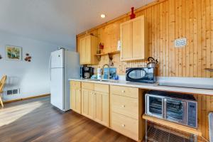 a kitchen with wooden cabinets and a refrigerator at Sanderling Sea Cottages, Unit 14 in Waldport