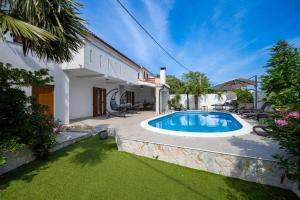 ein Hinterhof mit einem Swimmingpool und einem Haus in der Unterkunft Villa Goldie in Polje