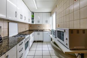 cocina grande con armarios y electrodomésticos blancos en Encantador apartamento con vistas al mar y AC, en San Pedro del Pinatar