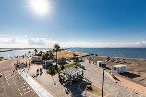 een uitzicht op een strand met de zon erboven bij Encantador apartamento con vistas al mar y AC in San Pedro del Pinatar