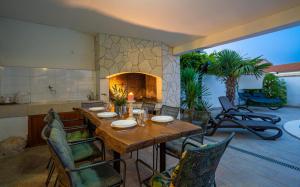 ein Esszimmer mit Tisch und Kamin in der Unterkunft Villa Goldie in Polje