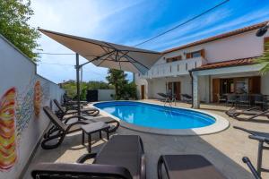 eine Villa mit Swimmingpool und Terrassenmöbeln in der Unterkunft Villa Goldie in Polje