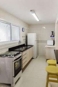 a kitchen with a stove and a refrigerator at Apto aconchegante com ar condicionado e wi-fi em rua tranquila in São Sebastião