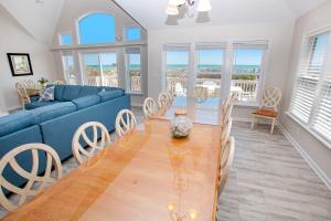 sala de estar con sofá azul y mesa en BU70, Kings Landing- Oceanfront, Private Pool, Pool Table, Ocean Views, en Corolla