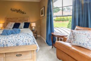 1 dormitorio con cama, sofá y ventana en Lakeview Retreat, en Oakwood