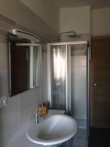 La salle de bains est pourvue d'un lavabo blanc et d'une douche. dans l'établissement Attico con garage coperto, à Turin