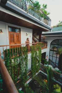 un homme debout sur un balcon d'une maison dans l'établissement Amarla Boutique Hotel Casco Viejo, à Panama City