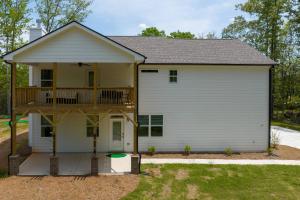 a house with a deck and a balcony at Hole in 1 in Gainesville