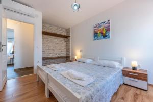 a bedroom with a bed and a brick wall at Villa Goldie in Polje