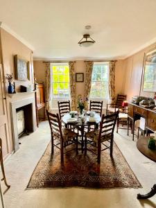 una cucina e una sala da pranzo con tavolo e sedie di Clarendon Cottage a Enfield