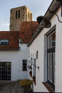 un bâtiment blanc avec une tour d'horloge en arrière-plan dans l'établissement Het Oud Gemeentehuis-De Levensboom, à Damme