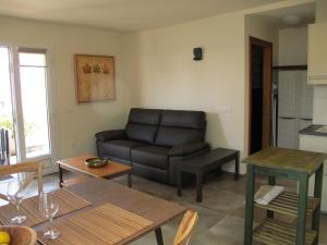 een woonkamer met een bank en een tafel bij Bungalow LIDO-Playa Roca residence with sea front access - Free AC - Wifi in Costa Teguise