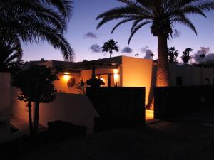 a house with a palm tree in front of it at Bungalow LIDO-Playa Roca residence with sea front access - Free AC - Wifi in Costa Teguise