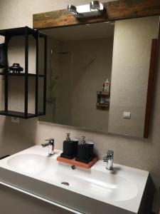 een wastafel in de badkamer met een grote spiegel erboven bij Bungalow LIDO-Playa Roca residence with sea front access - Free AC - Wifi in Costa Teguise