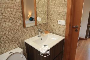 パレーデス・デ・コウラにあるCasa Santa Marinhaのバスルーム(洗面台、鏡、トイレ付)