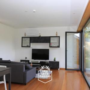 a living room with a couch and a tv at Casa Santa Marinha in Paredes de Coura