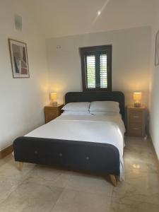 a bedroom with a large bed with two night stands at 2 Bed Flat - Sleeps 6 - Pool - Garden - Parking in Milna