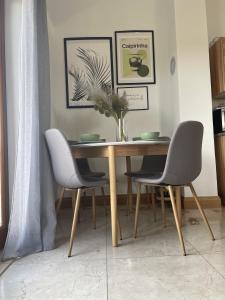 a dining room table with two chairs and a vase on it at 2 Bed Flat - Sleeps 6 - Pool - Garden - Parking in Milna