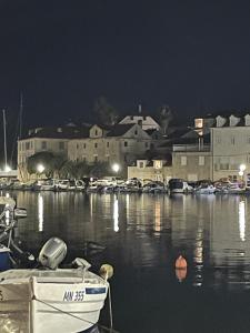 a boat is docked in a marina at night at 2 Bed Flat - Sleeps 6 - Pool - Garden - Parking in Milna