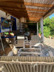 eine Terrasse mit 2 Stühlen und einem Tisch in der Unterkunft Casa Rural La ilusion in Málaga