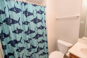 a bathroom with a shark shower curtain with a toilet at KD9, Sealoft- Soundside, Cozy, Close to Shopping and stores! in Kill Devil Hills