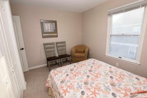 - une chambre avec un lit, une chaise et une fenêtre dans l'établissement KD9, Sealoft- Soundside, Cozy, Close to Shopping and stores!, à Kill Devil Hills