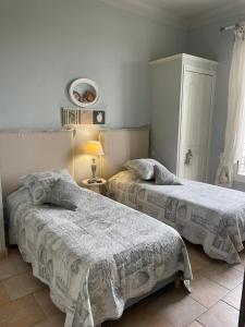 a bedroom with two beds and a lamp at Toi & Moi in Sainte-Maxime