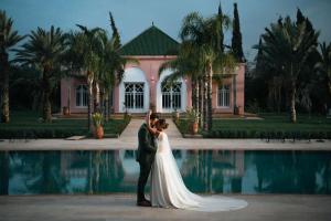 a bride and groom standing in front of a pool at The Levantine in Marrakesh
