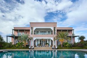 a large pink house with a swimming pool in front of it at The Levantine in Marrakesh